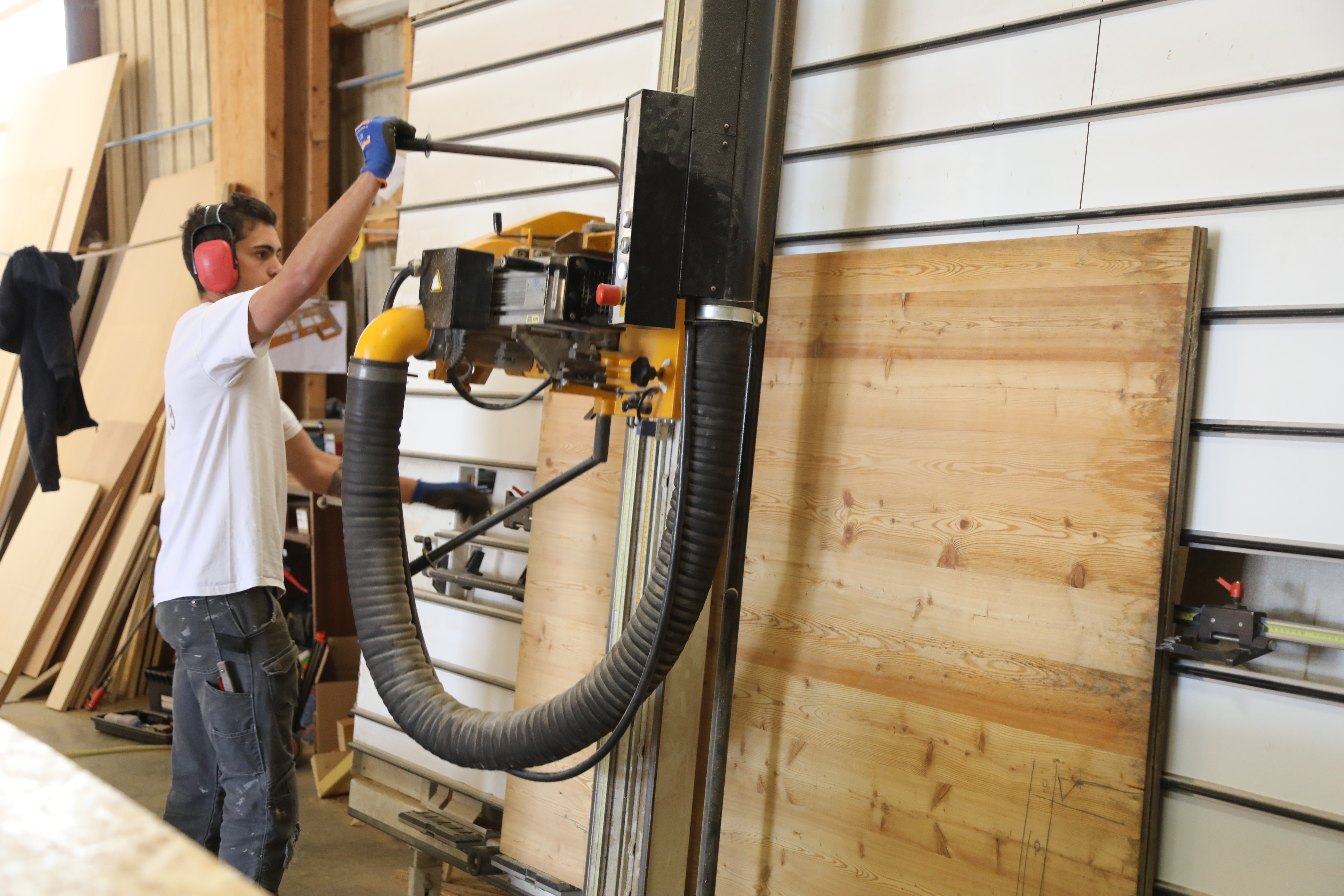 Photo qui montre une personne de l’entreprise en train de préfabriquer des éléments d’une maison en bois